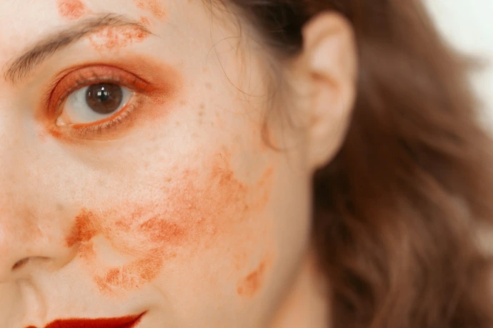 Woman with red paint smudges on face